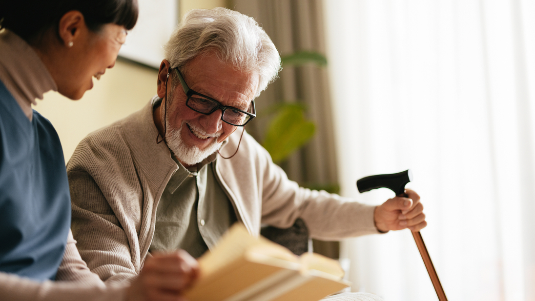 Nurse reading a book with senior patient in assisted living.jpg