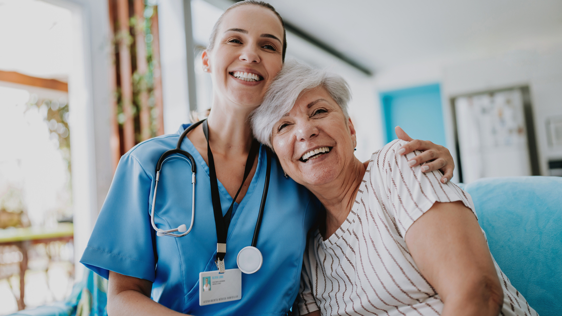 Home care healthcare professional hugging senior patient