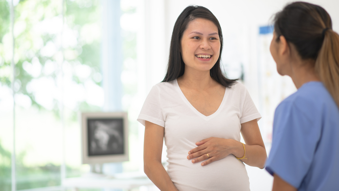 Pregnant woman speaks with doctor.jpg