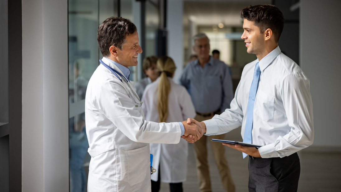 Sales representative greeting a doctor with a handshake at the hospital.jpg
