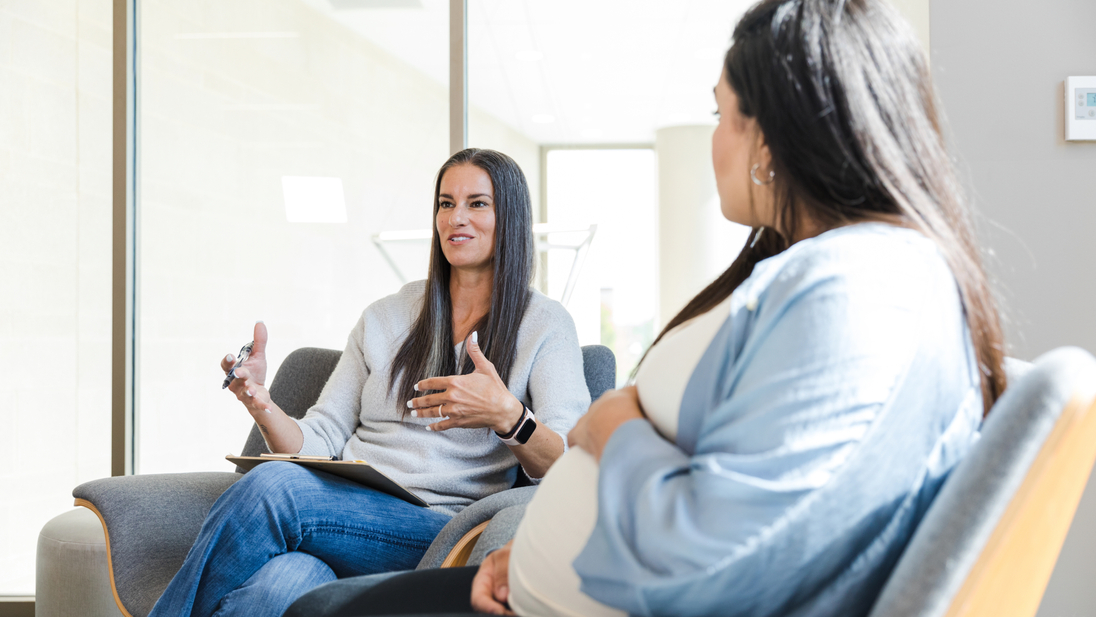 Pregnant adult woman listens to an adult female therapist.jpg